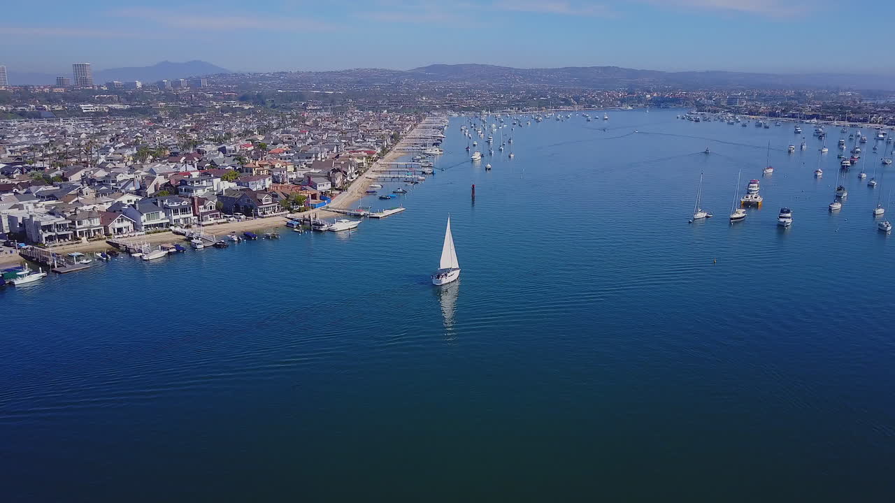 Drone footage of a sailboat in Newport Bay, Newport Beach, California.