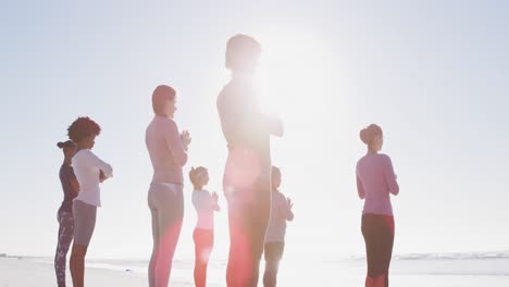 Multiethnische-Gruppe-Von-Frauen,-Die-Yoga-Am-Strand-Und-Vor-Blauem-Himmel-Machen