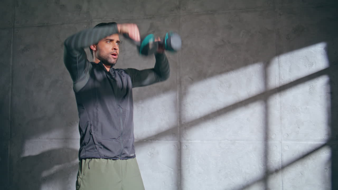 Squats man holding weights indoor health club closeup. Guy weightlifting workout