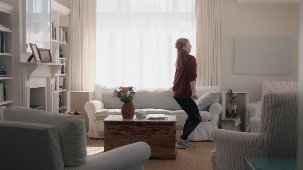 junge frau tanzt zu hause, hat spaß, feiert mit lustigen tanzbewegungen, genießt die freiheit am wochenende 4k-filmmaterial