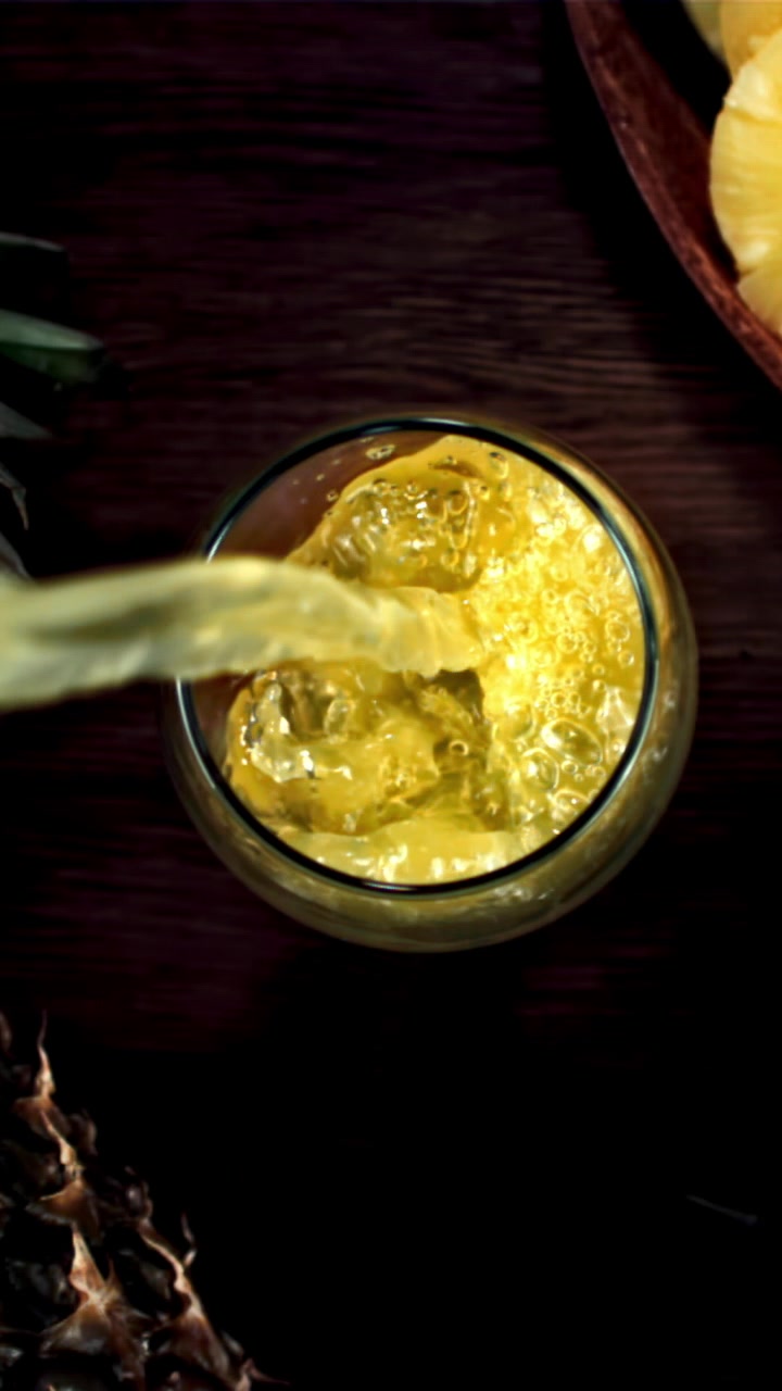 Succo d'ananas rinfrescante versato in un bicchiere con ghiaccio