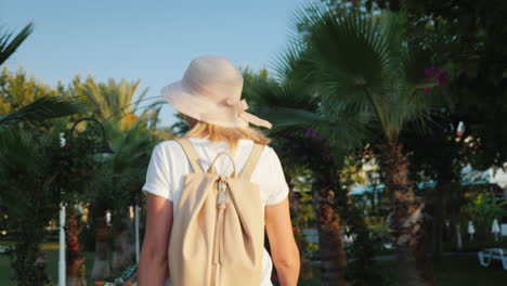 A-Tourist-With-A-Pink-Backpack-Behind-Her-Back-Walks-Along-The-Avenue-Of-Palm-Trees-Rest-And-New-Imp