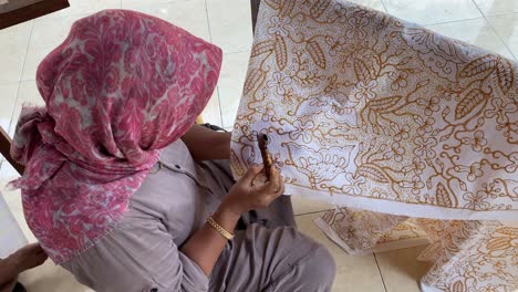 these mothers are making batik using the technique of making hand-drawn batik using a canting tool. these craftsmen make typical giriloyo bantul yogyakarta batik.