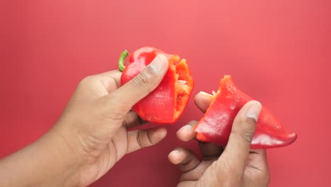 manos sosteniendo un pimienta roja cortada por la mitad