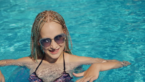 portrait of a child in the pool, looking into the camera, smiling