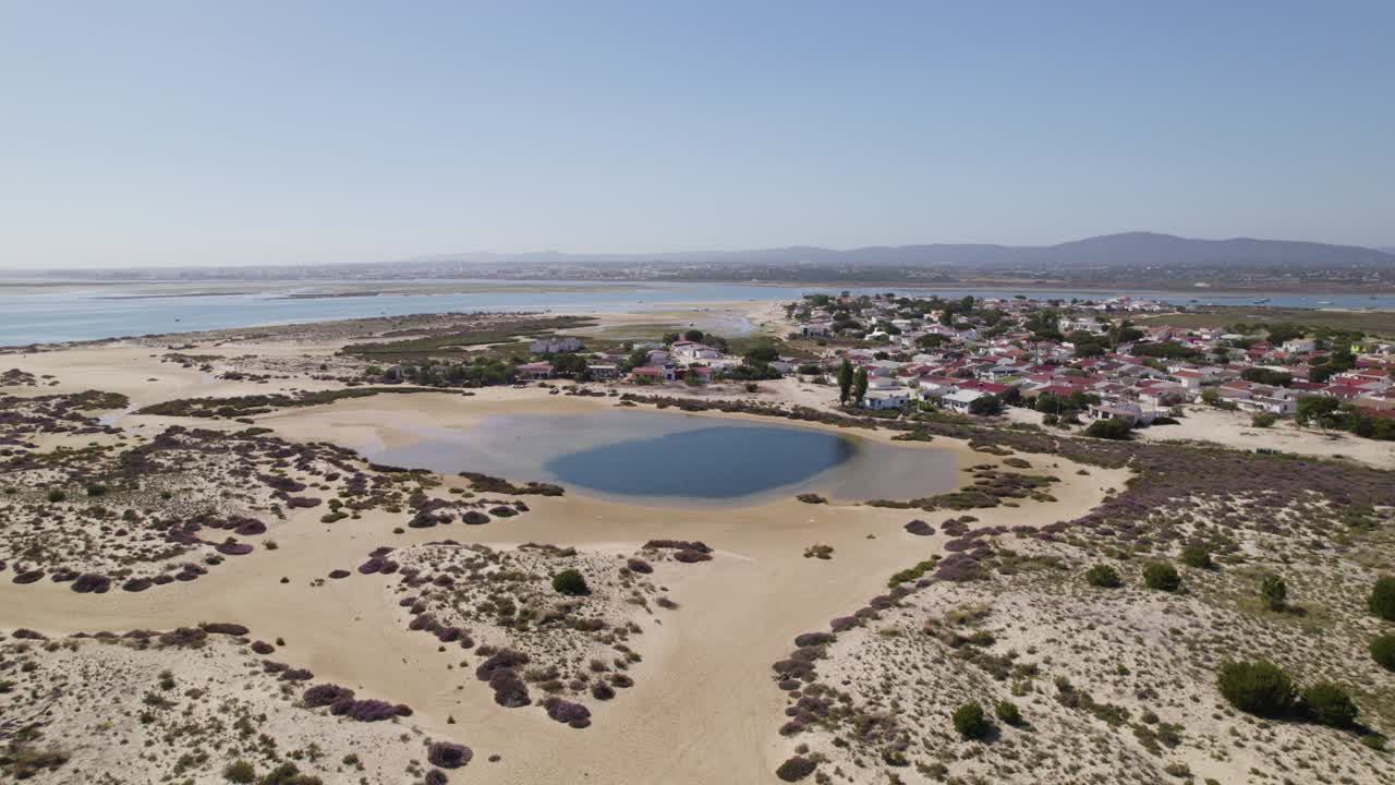 Kiertävä ilmakuva pienestä laguunista Armonan saaren hiekkadyyneillä, Algarvessa, Portugalissa.