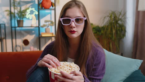 Una-Mujer-Bonita-Se-Sienta-En-El-Sofá-Comiendo-Palomitas-De-Maíz,-Viendo-Un-Interesante-Juego-Deportivo-En-Serie-De-Televisión-En-Línea-En-Casa