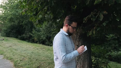 hombre con gafas escribe en un cuaderno