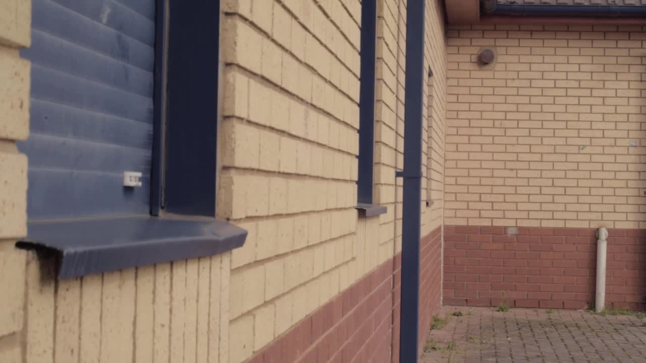Closed brick building with shutters down tilting shot