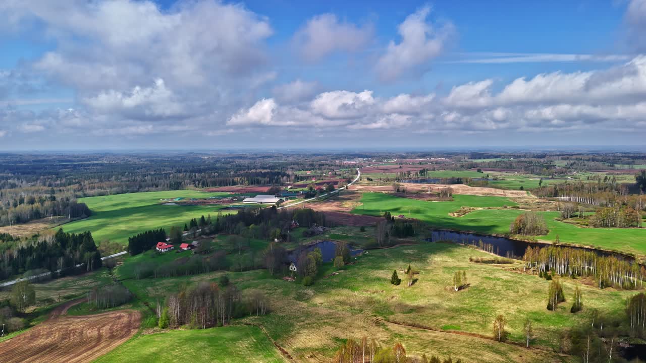 Droneutsikt over et vakkert grønt landlig landskap under en blå himmel.