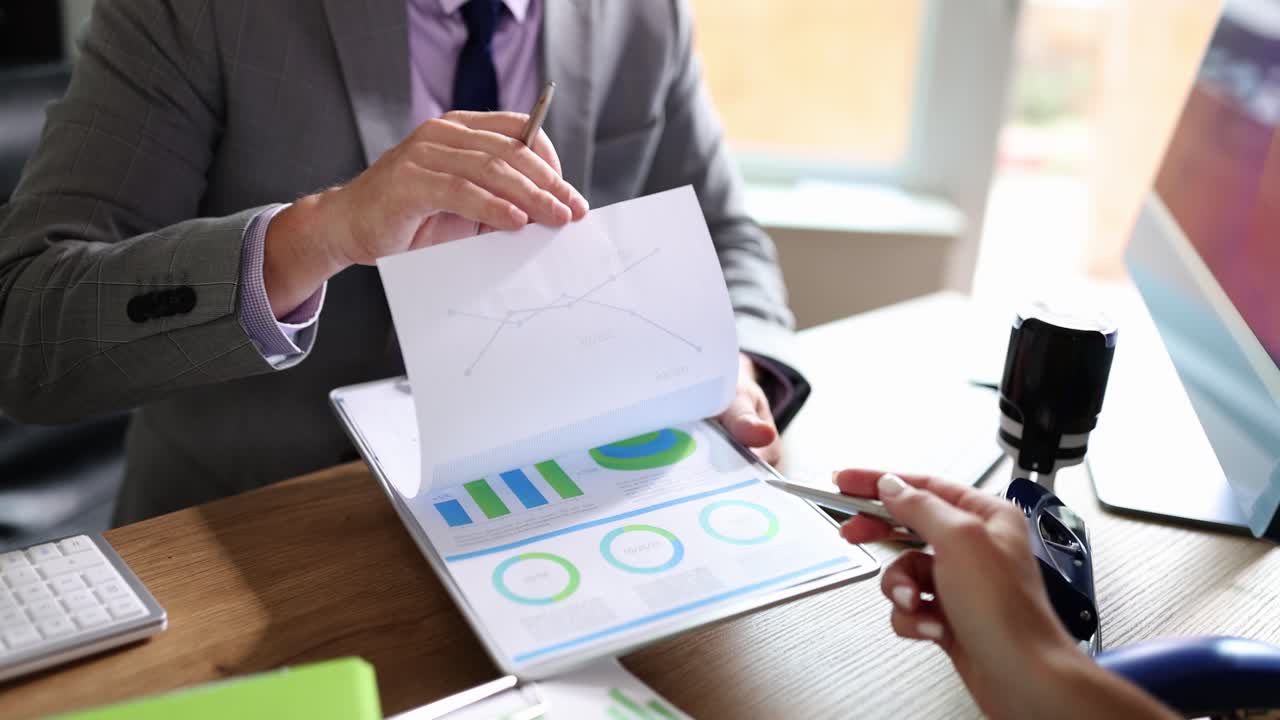 Business professionals reviewing documents and charts in an office meeting