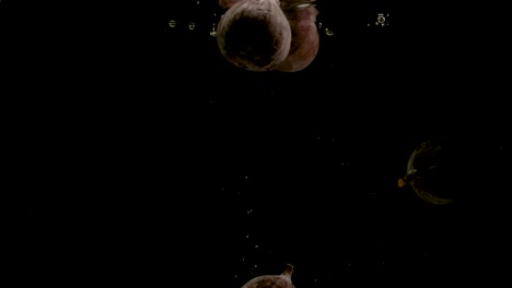 higos cayendo en el agua sobre un fondo negro. brillante video de alta calidad