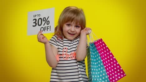 chica feliz sosteniendo bolsas de compras y letrero de venta