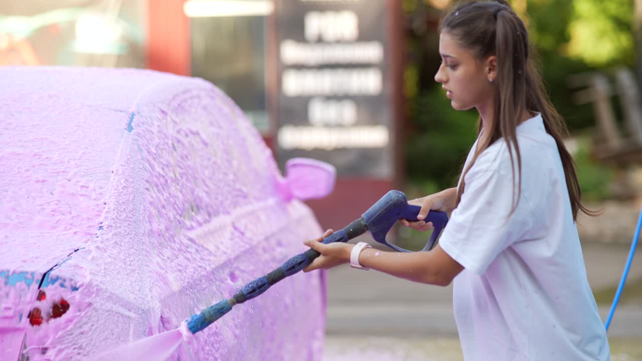mujer lavando un coche con espuma rosa