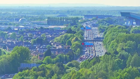 busy highway with traffic near trafford centre large indoor shopping centre and entertainment complex in trafford park, greater manchester, england, crane up drone shot