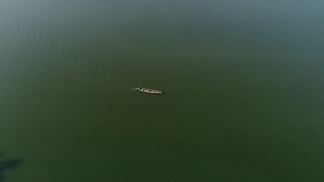 imágenes de drones de un lago con un barco viajando