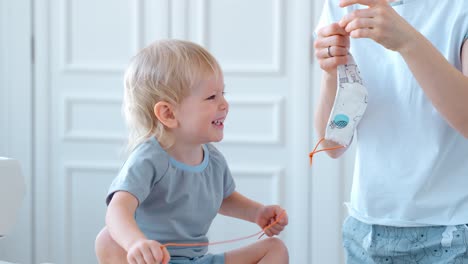 mother helping a child put on a face mask