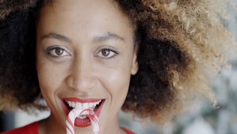 divertido, mujer joven, morder, navidad, bastón de caramelo
