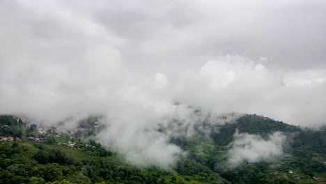 Stadt-Eingebettet-In-Bergkette-Mit-Sich-Schnell-Bewegenden-Weißen-Wolken-Am-Morgen-Aus-Flachem-Winkel