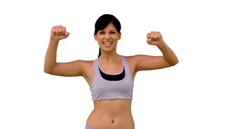 una mujer en forma tensando los músculos de su brazo.