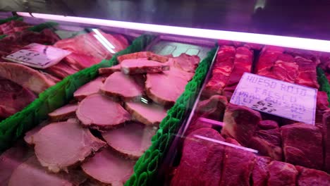 case filled with several pig's feet (patitas de cochino), a common item in spanish-speaking markets. paper tags with prices in dollars and bolivares. dramatic and vibrant visual