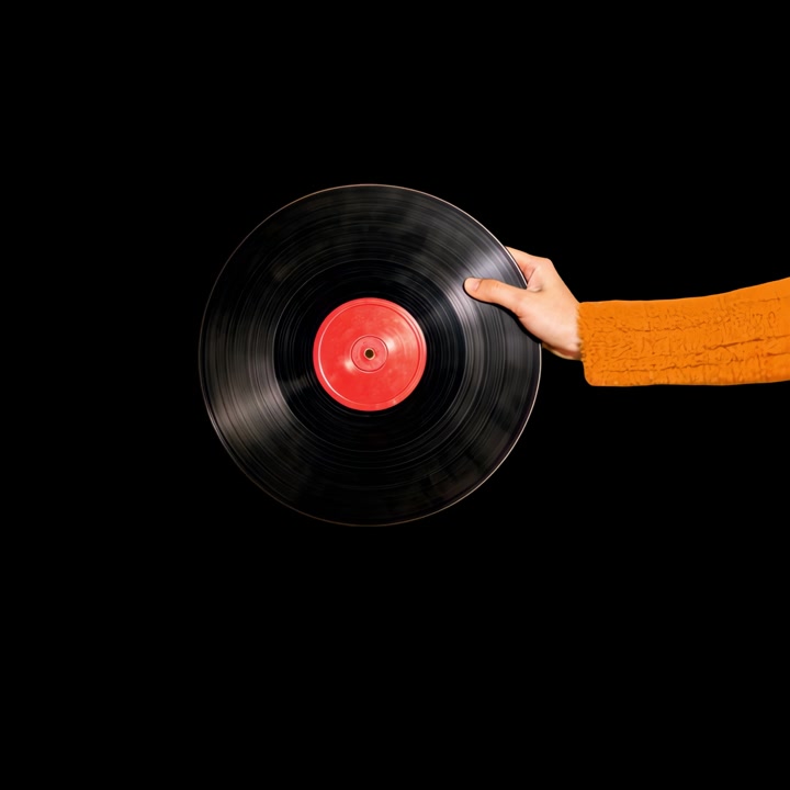 Mano che tiene un disco in vinile rotante su sfondo nero