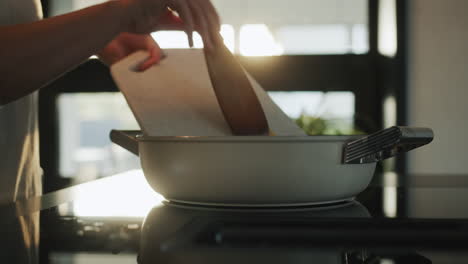 woman frying vegetables in a frying pan