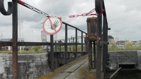 cinematic arc shot of a no trespassing sign on a dry dock bridge