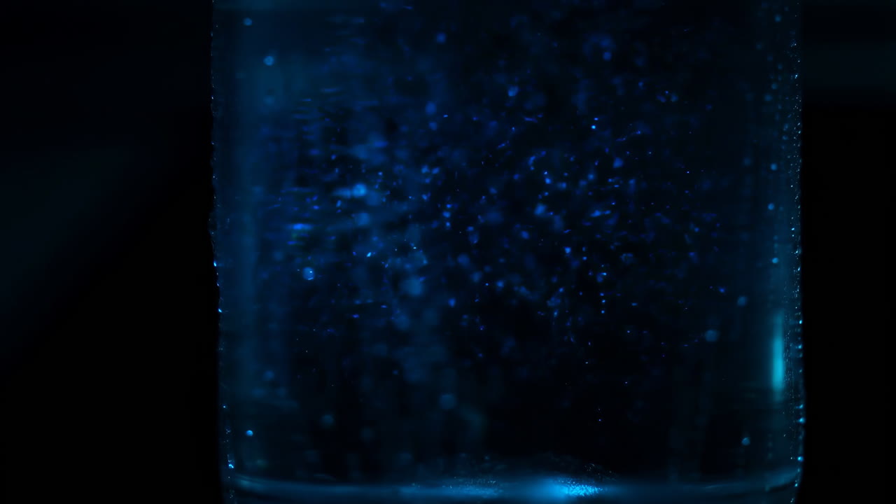 Abstract Blue Glowing Particles in Dark Liquid