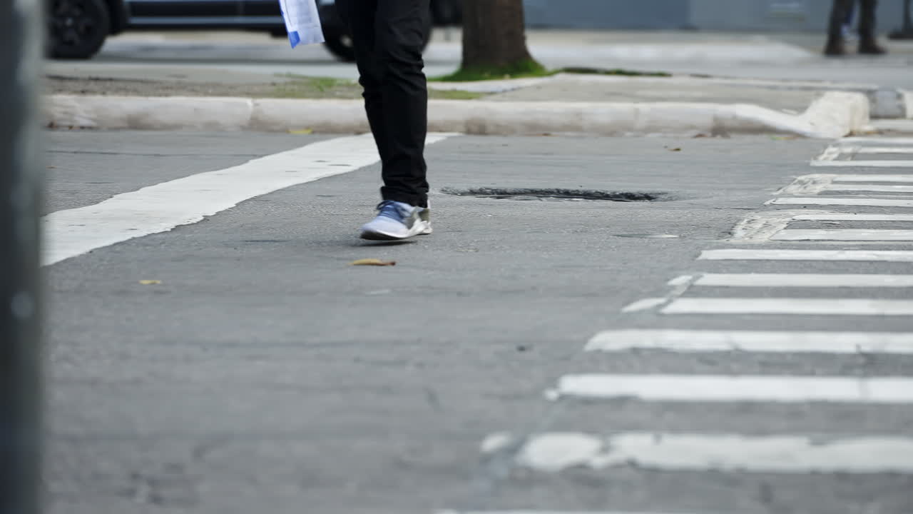 4k 고화질로 슬로우 모션으로 촬영된 대낮에 대도시의 횡단보도 옆에서 길을 건너는 보행자