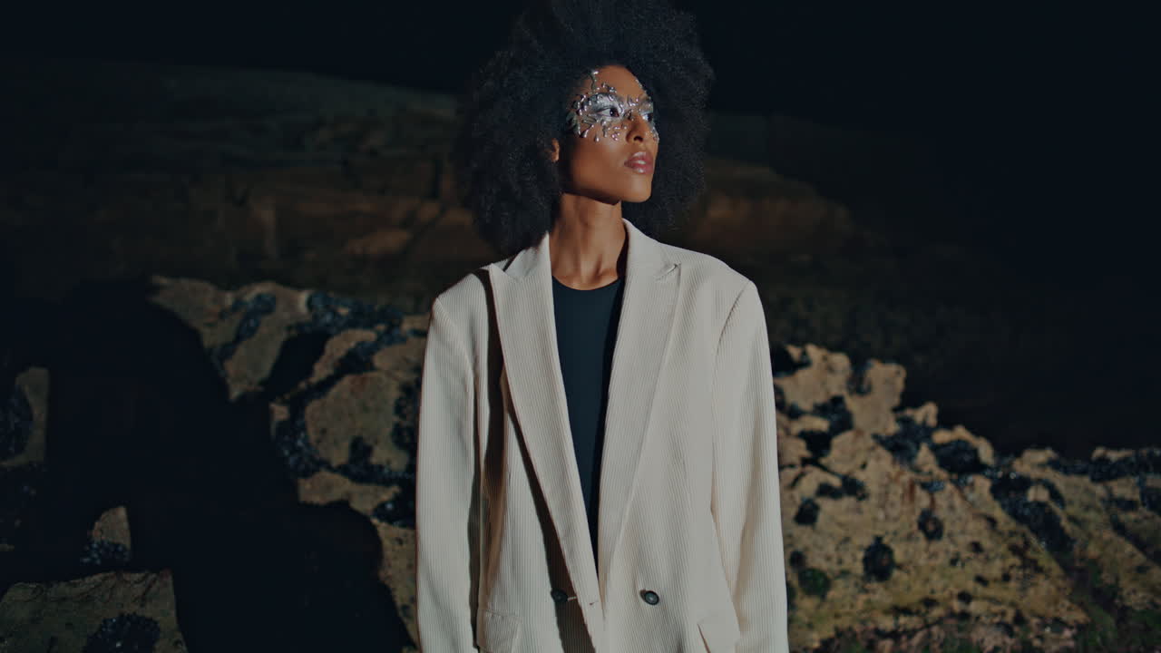 Stylish lady posing rocky shore at night. Festival   with makeup