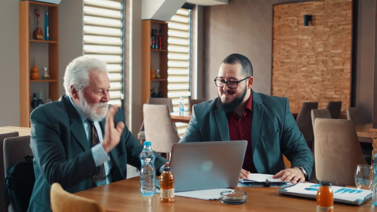 사업가 와 노인 사업주 가 사업 회의 를 위해 식당 에 오고 있다