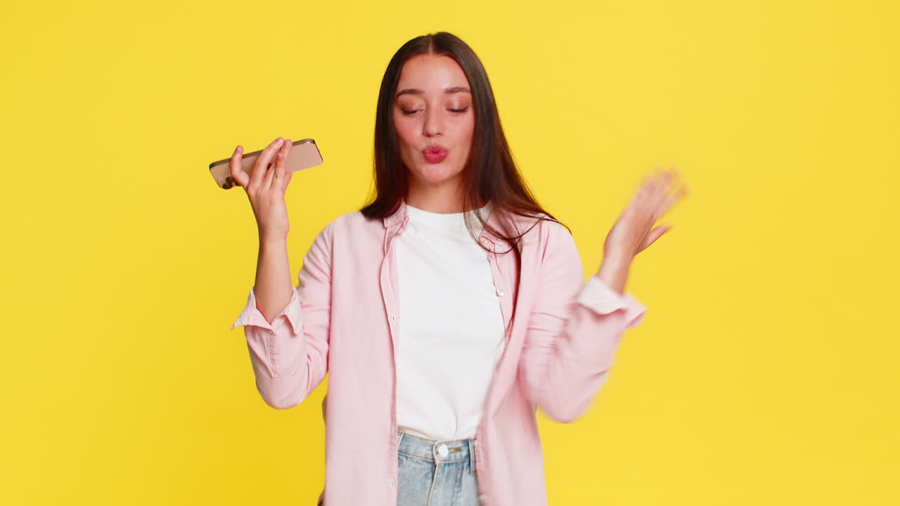 Donna che balla ritmicamente a musica riprodotta da uno smartphone: gioiosa, energica, espressiva, allegra
