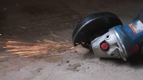 circular saw cutting metal generating sparks. worker grinding metal with handheld round circular saw. slow motion