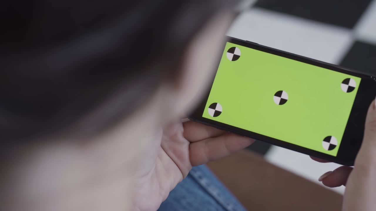 persona mirando un teléfono inteligente con una pantalla verde