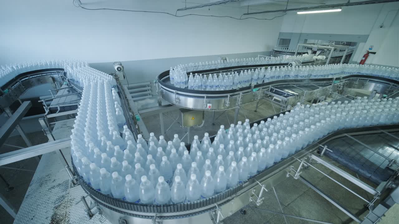cinta transportadora con botellas de agua potable en una planta de bebidas moderna