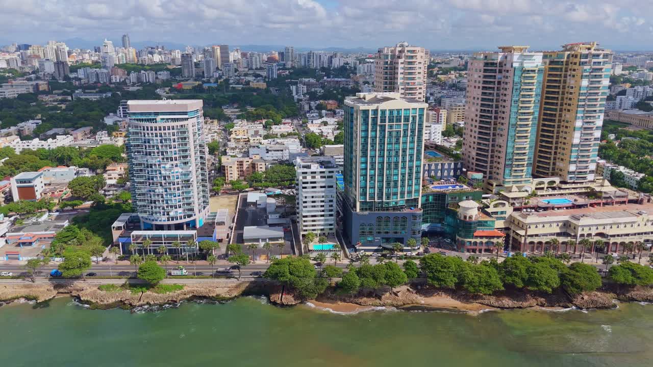 fotografía aérea detallada sobre el malecón en santo domingo mostrando la avenida george washington, los edificios a lo largo de la costa, el tráfico fluido y las olas del océano