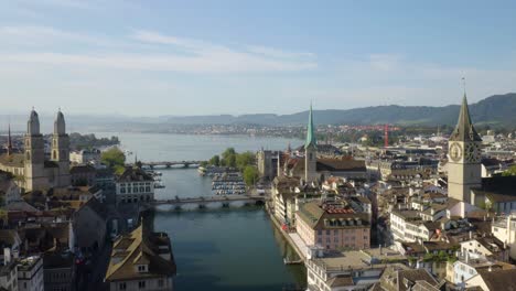 Fixed-Aerial-Shot-of-Grossmünster-Church,-Fraümunster,-and-Church-of-St-Peter-on-Summer-Day