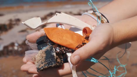 Closeup-Detail-of-Woman-Hands-Holding-Plastic-Pollution-Waste-on-Beach