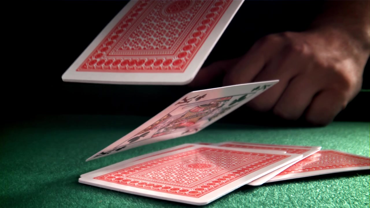 Playing Cards Falling onto a Green Felt Table in Slow Motion