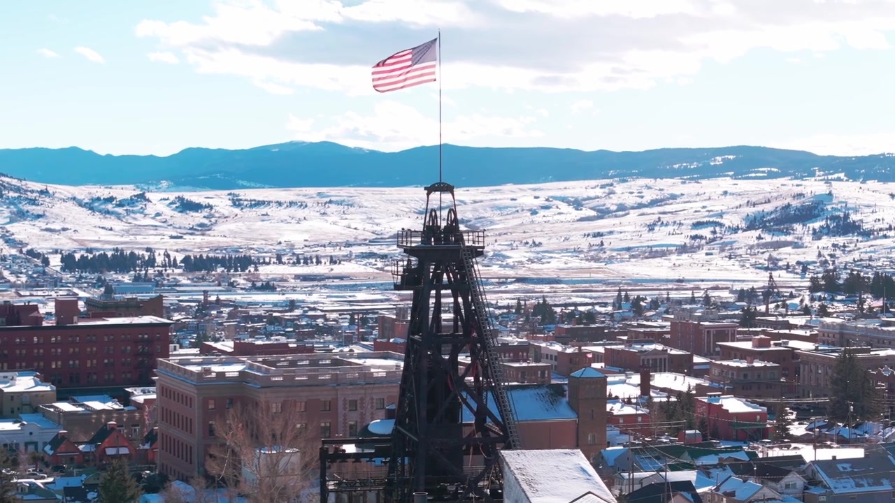Veduta aerea invernale su Butte, Montana, che mostra storici castelli minerari ed edifici storici del centro coperti di neve sotto un cielo sereno