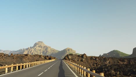 highway road leading toward mountain of teide national park, pov driving