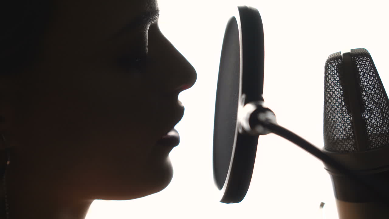 Beautiful young singer who recorded a song in a professional recording studio. Close-up face.