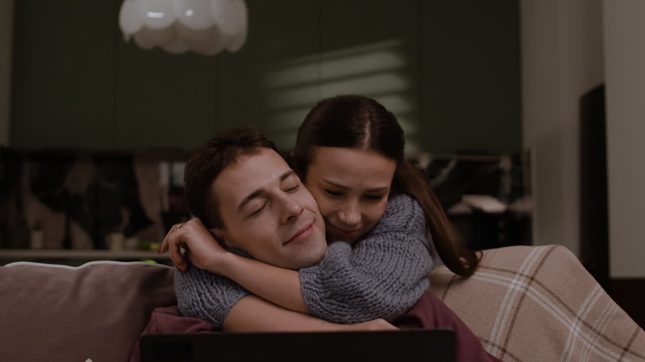 Couple interacts around laptop