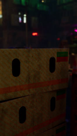 stacked cardboard boxes on a city street at night