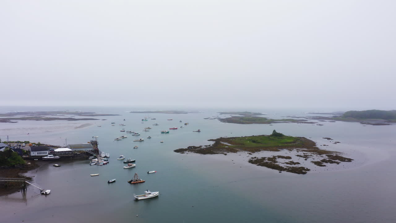 Drone shot of marina in Maine with lobster fishing boats and empty pier 4k 30p