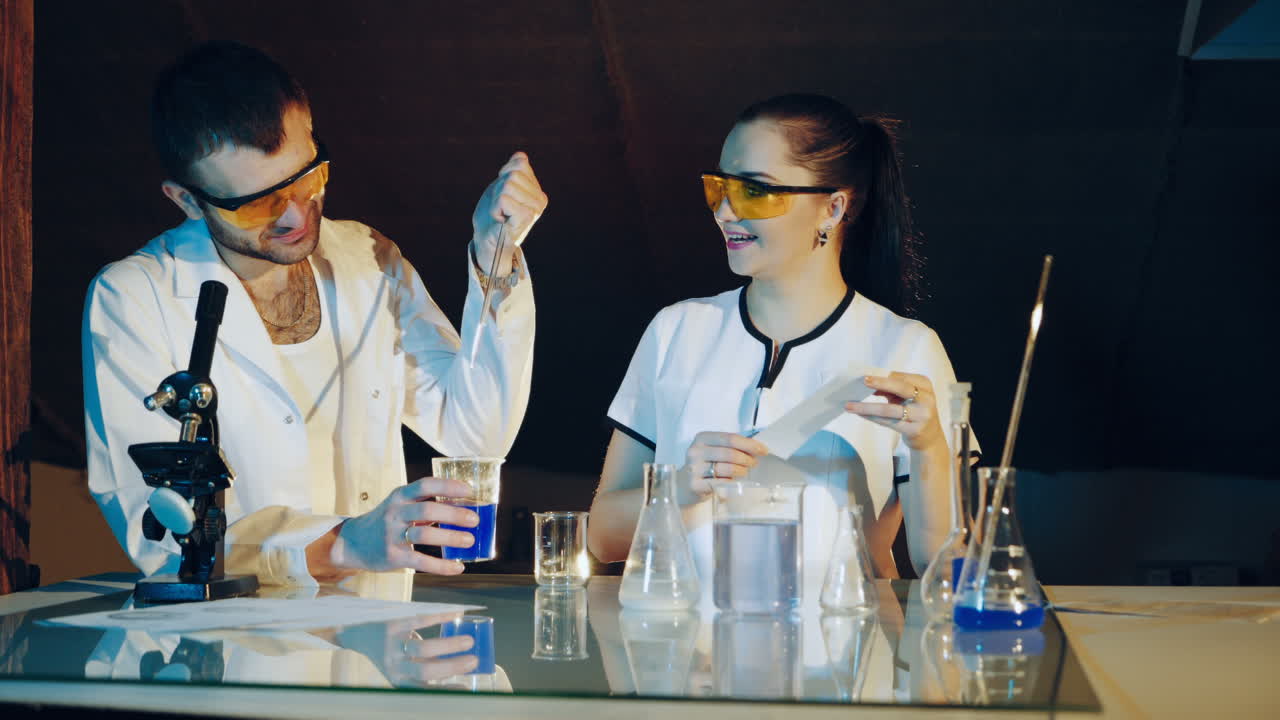 Two chemists examine various liquids in the tubes. Experiments in the laboratory