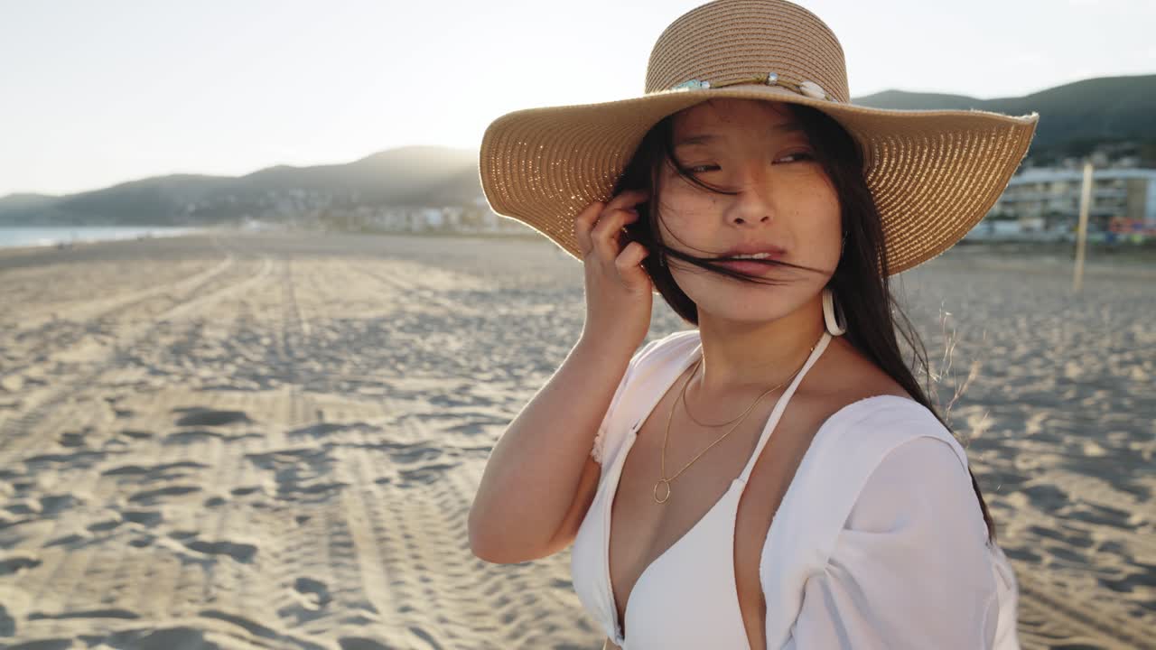 mujer con un sombrero de paja en la playa