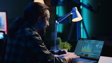 Smiling-man-satisfied-about-statistical-data-financial-graphs-on-laptop-screen