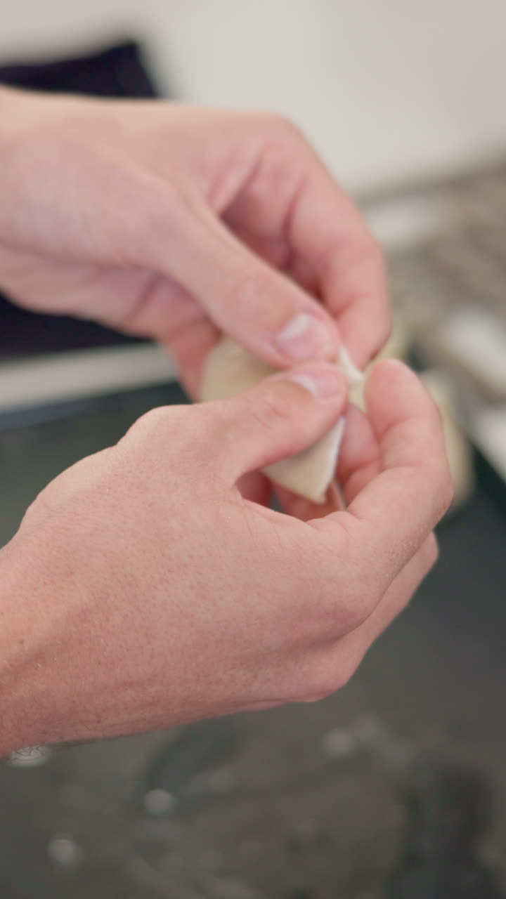 Hands preparing a dumpling